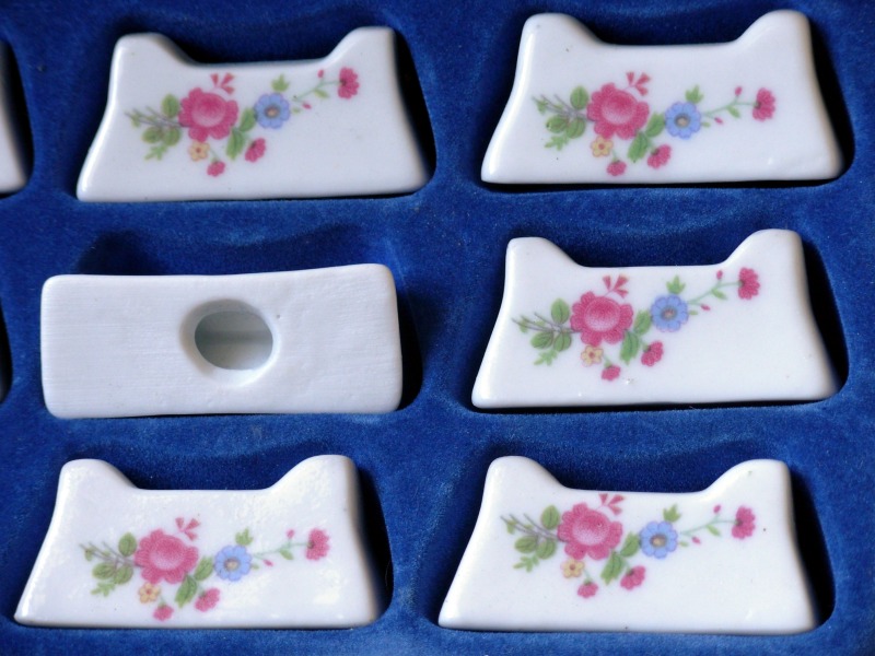 12 anciens porte-couteaux en porcelaine