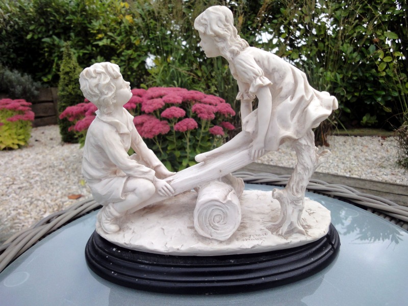 Statuette d enfants jouant sur une balanÃ
oire